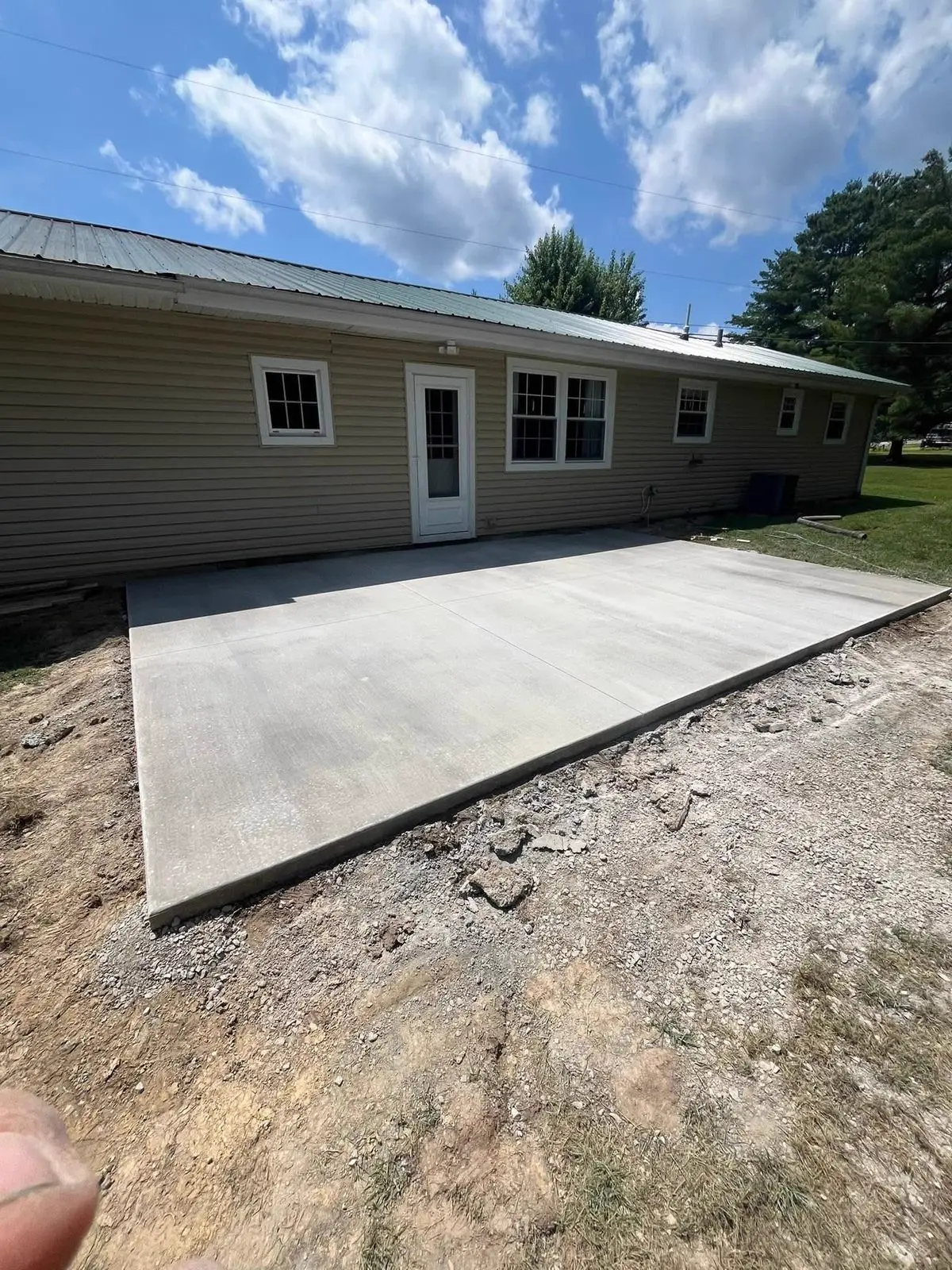 New concrete patio slab poured behind a home