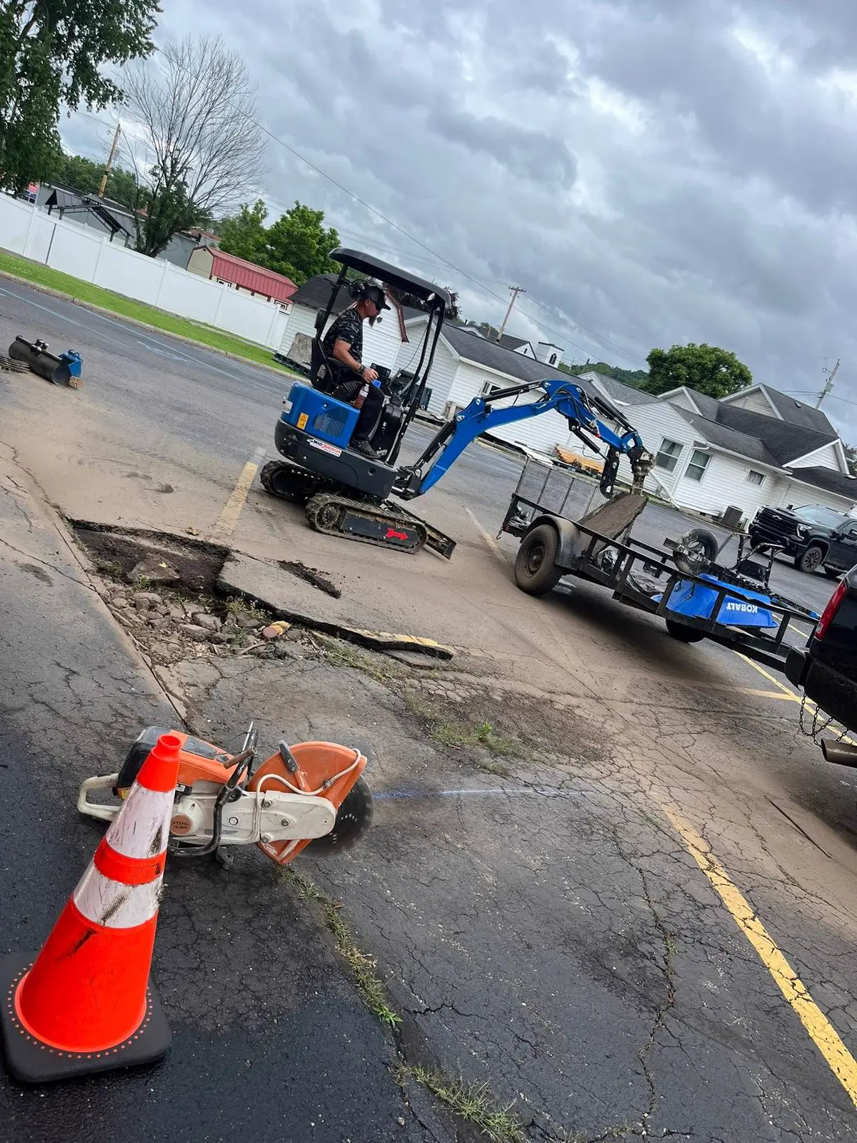 Excavator and saw removing old concrete